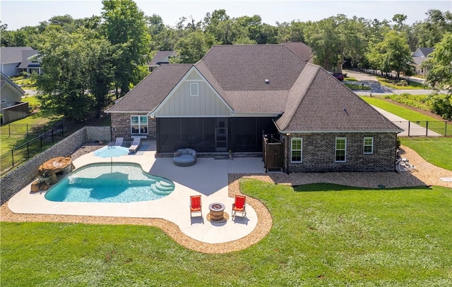 98 Bartram Trl, Brunswick, GA 31523 - back of property featuring a sunroom, a patio area, board and batten siding, and roof with shingles