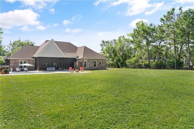 98 Bartram Trl, Brunswick, GA 31523 - back of house featuring a sunroom, a lawn, a patio area, and board and batten siding