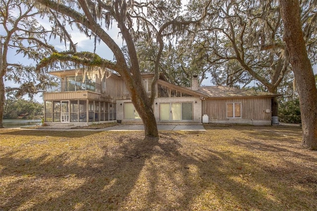 rear view of house featuring a sunroom and a balcony