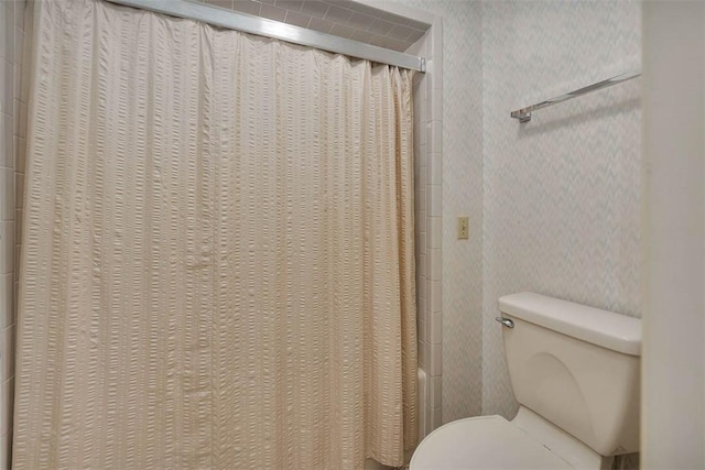 bathroom featuring shower / tub combo with curtain and toilet