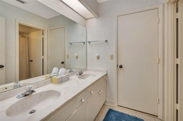 full bathroom with wallpapered walls and a sink