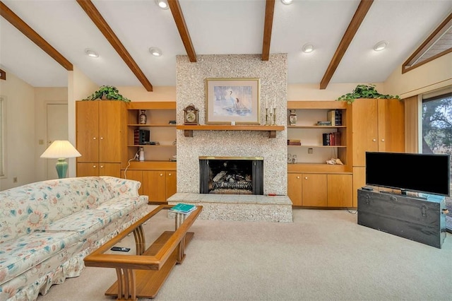 living room with built in features, light colored carpet, a fireplace with raised hearth, and vaulted ceiling with beams