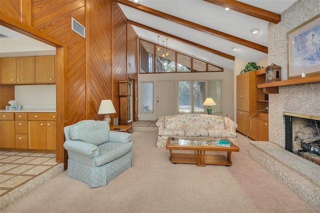 living room featuring light colored carpet, a fireplace with raised hearth, visible vents, high vaulted ceiling, and beamed ceiling