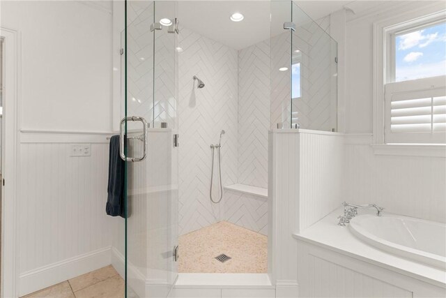 553 Park Ave, Saint Simons Island, GA 31522 - full bath featuring a garden tub, a stall shower, tile patterned flooring, a wainscoted wall, and a decorative wall