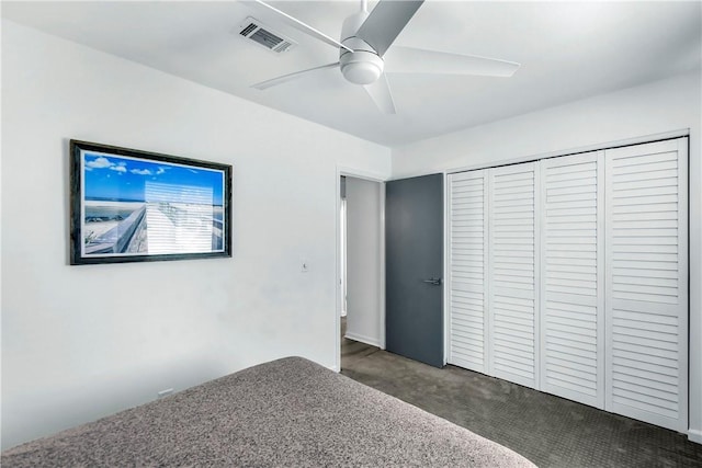 unfurnished bedroom featuring dark colored carpet, a closet, and ceiling fan