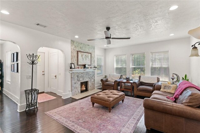 686 S Fourth St, Jesup, GA 31545 - living room featuring ceiling fan, dark wood-style flooring, recessed lighting, arched walkways, and a tiled fireplace