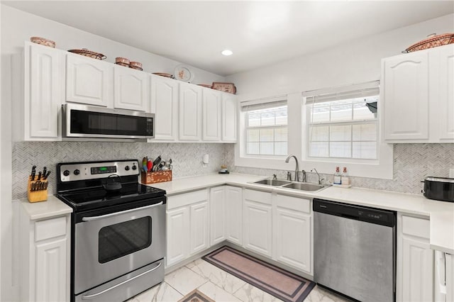 686 S Fourth St, Jesup, GA 31545 - kitchen featuring appliances with stainless steel finishes, white cabinets, light marble finish floors, tasteful backsplash, and light countertops
