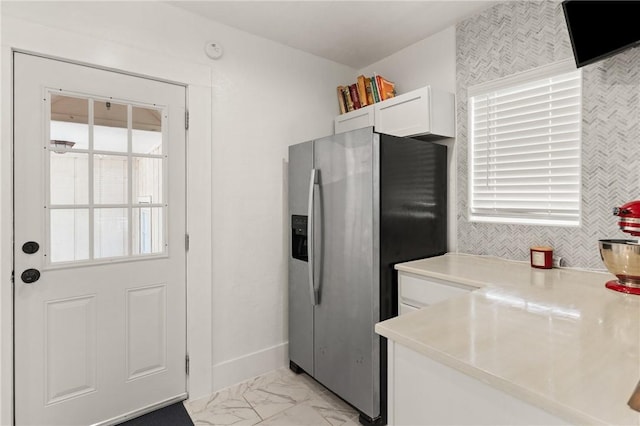 686 S Fourth St, Jesup, GA 31545 - kitchen with stainless steel fridge with ice dispenser, light marble finish floors, white cabinetry, and healthy amount of natural light