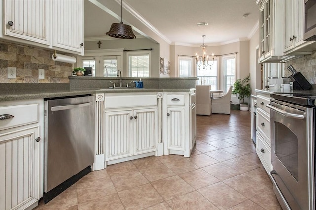 4901 Stanfield Rd, Patterson, GA 31557 - kitchen featuring appliances with stainless steel finishes, a chandelier, tasteful backsplash, crown molding, and a peninsula