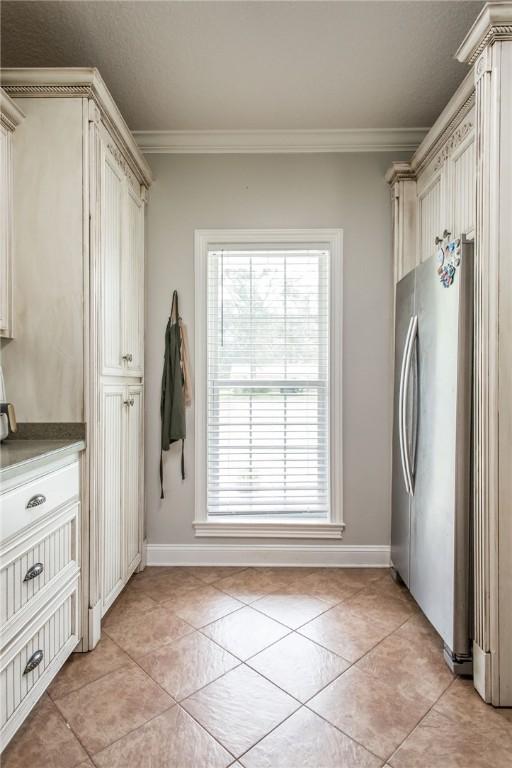 4901 Stanfield Rd, Patterson, GA 31557 - washroom featuring crown molding, light tile patterned flooring, and cabinet space