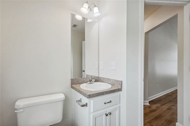 bathroom with vanity, hardwood / wood-style flooring, and toilet