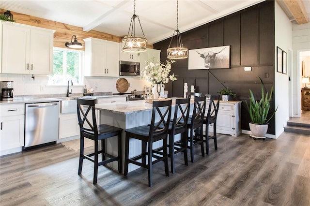 313 White Pine Highway, Nicholls, GA 31554 - kitchen with appliances with stainless steel finishes, wood finished floors, a sink, white cabinets, and beamed ceiling