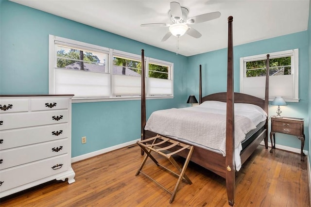 bedroom with multiple windows, ceiling fan, and wood-type flooring