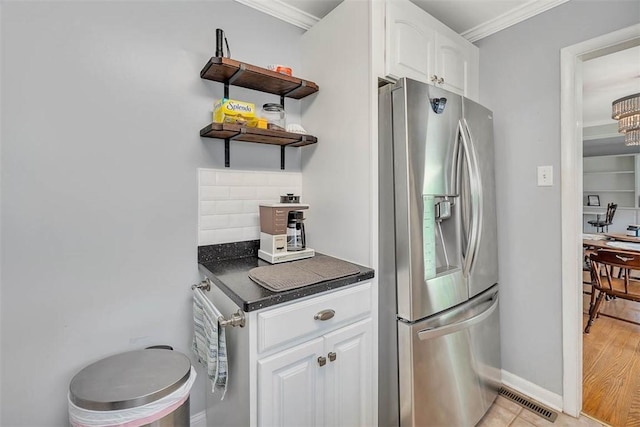 kitchen featuring tasteful backsplash, stainless steel fridge with ice dispenser, crown molding, white cabinets, and light wood-type flooring