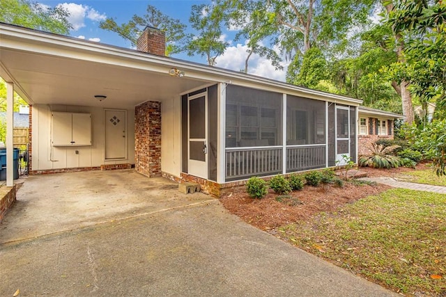 view of front of house with a sunroom and a carport