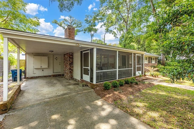 view of front of house with a sunroom and a carport