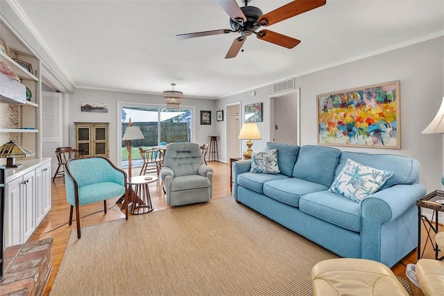 living room featuring ceiling fan, ornamental molding, and light hardwood / wood-style flooring