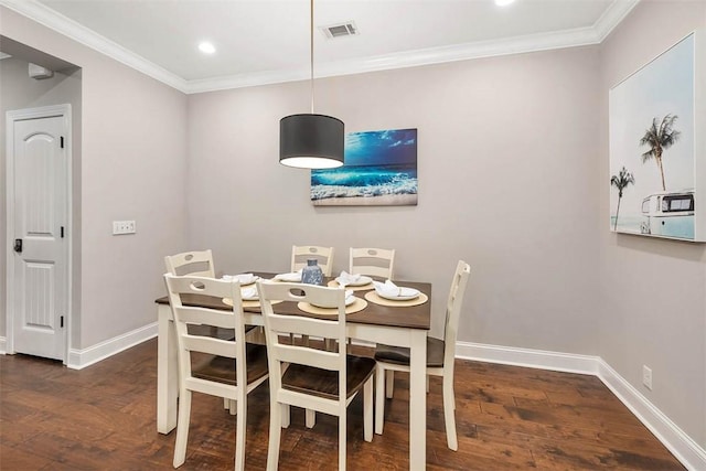 dining space featuring ornamental molding and dark hardwood / wood-style floors