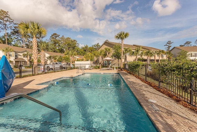 pool featuring a residential view, a patio area, and fence