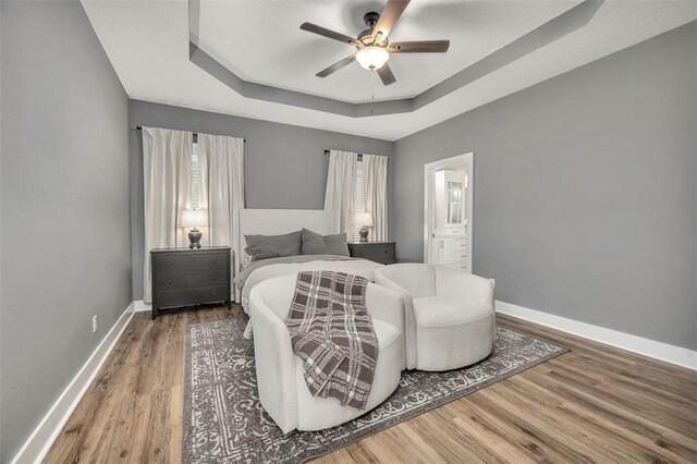 12 Hunters Dr, Brunswick, GA 31523 - bedroom with a raised ceiling, wood finished floors, multiple windows, and ensuite bathroom
