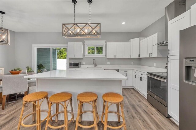 12 Hunters Dr, Brunswick, GA 31523 - kitchen featuring stainless steel appliances, a kitchen bar, light wood finished floors, light countertops, and recessed lighting