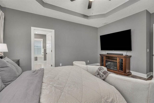 12 Hunters Dr, Brunswick, GA 31523 - bedroom featuring wood finished floors, ensuite bath, ceiling fan, and a tray ceiling