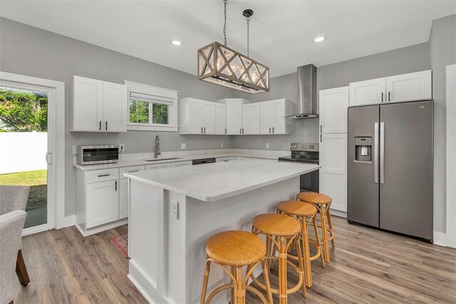 12 Hunters Dr, Brunswick, GA 31523 - kitchen with stainless steel appliances, wall chimney exhaust hood, healthy amount of natural light, light wood-type flooring, and recessed lighting
