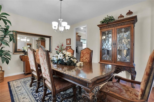 dining space featuring an inviting chandelier and light wood-type flooring