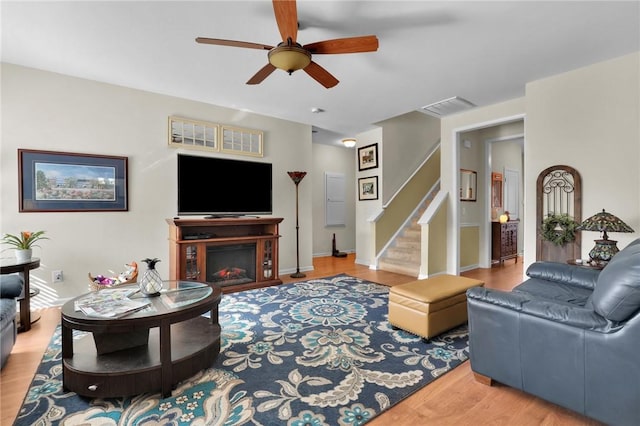 living room featuring ceiling fan and light wood-type flooring