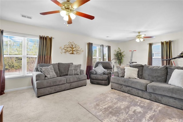 living room featuring ceiling fan, plenty of natural light, and light carpet