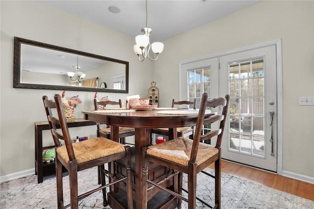 dining room with french doors, an inviting chandelier, and wood-type flooring