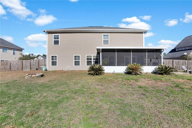 rear view of house featuring a sunroom and a yard