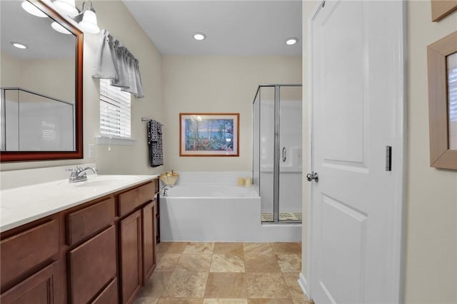 bathroom featuring vanity and independent shower and bath