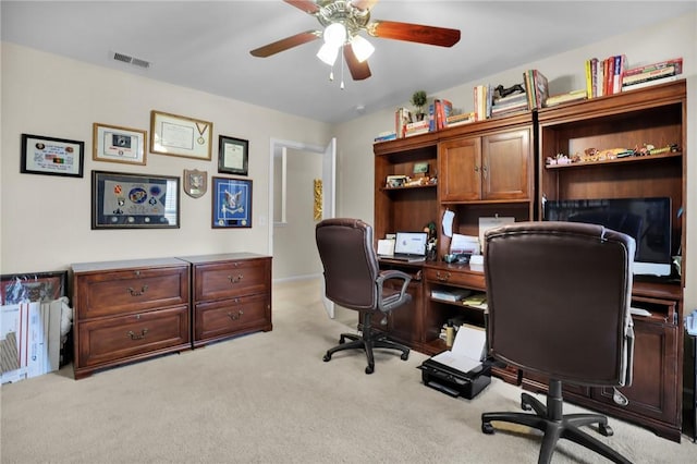 carpeted home office featuring ceiling fan