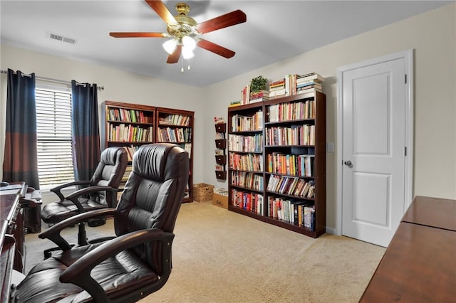 carpeted office space featuring ceiling fan