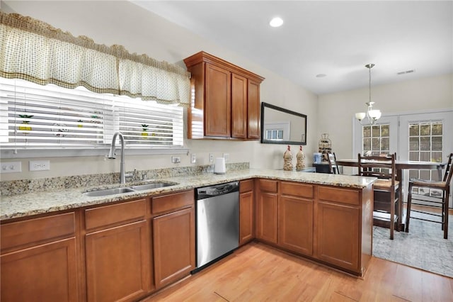 kitchen with decorative light fixtures, light hardwood / wood-style floors, stainless steel dishwasher, kitchen peninsula, and sink