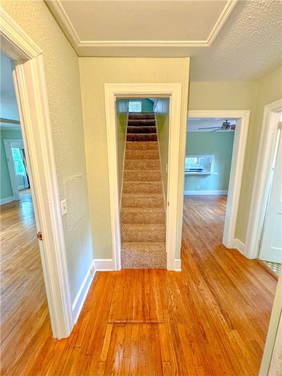 hall with a textured ceiling and light wood-type flooring