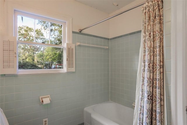 bathroom featuring shower / tub combo and tile walls