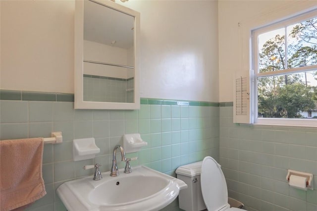 bathroom with tile walls, sink, and toilet