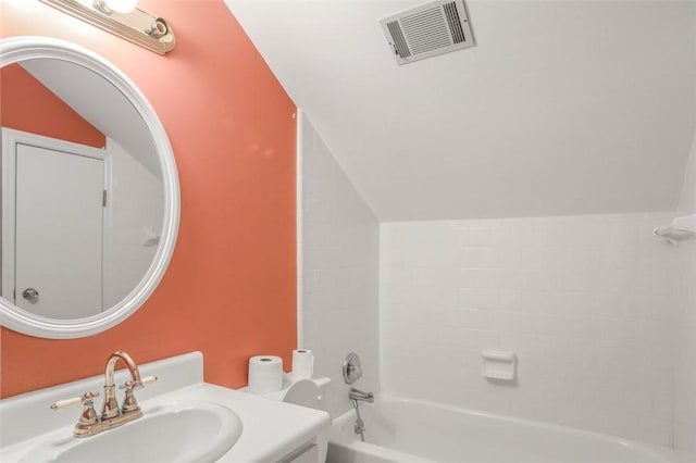 bathroom with vanity, lofted ceiling, and shower / washtub combination