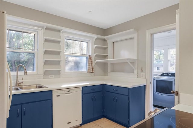 kitchen featuring sink, white appliances, blue cabinetry, a wealth of natural light, and washer / clothes dryer