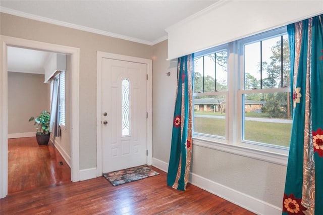 foyer with ornamental molding and dark hardwood / wood-style flooring