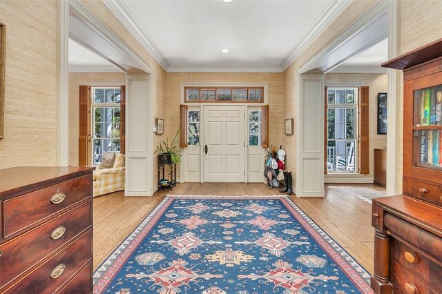 foyer featuring crown molding and light hardwood / wood-style flooring