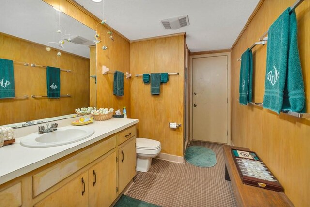 bathroom with vanity, tile patterned floors, toilet, ornamental molding, and walk in shower