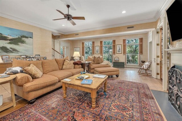 living room featuring ceiling fan, light wood-type flooring, and ornamental molding