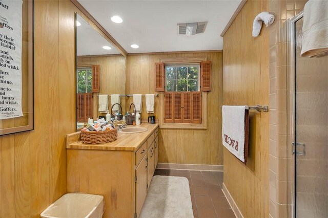 bathroom featuring tile patterned flooring, vanity, wood walls, and an enclosed shower