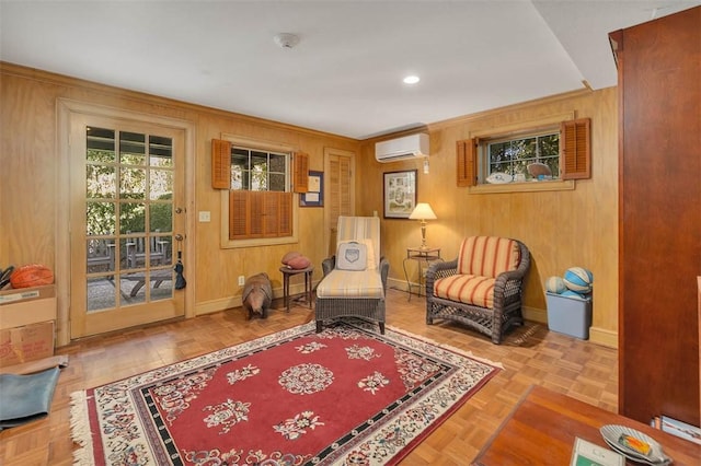 sitting room featuring light parquet flooring, a wall mounted AC, and wood walls