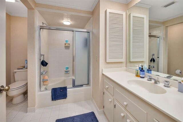 full bathroom featuring vanity, tile patterned floors, combined bath / shower with glass door, toilet, and ornamental molding