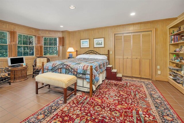 tiled bedroom featuring wood walls and a closet