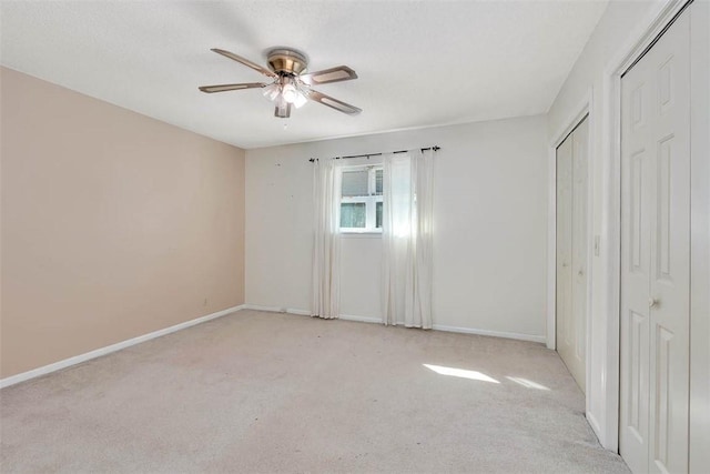 unfurnished bedroom featuring light carpet and ceiling fan